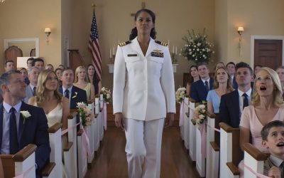 La veille de mon mariage, mes parents ont coupé ma robe en deux et m’ont dit que je le « méritais ». Mais lorsque les portes de la chapelle se sont ouvertes et que je suis entrée en uniforme de la Marine, avec deux étoiles sur les bretelles, mon frère a murmuré : « Waouh… Regarde les ornements ! » C’est seulement à ce moment-là que mes parents ont enfin compris : la fille qu’ils avaient tenté de briser était devenue la personne la plus forte de cette église. Ce n’est pas le conte de fées que l’on imagine pour son mariage. La nuit précédant la cérémonie, je suis restée éveillée dans ma vieille chambre, dans une petite ville de Virginie, à écouter le silence s’installer dans la rue. Une petite chapelle blanche, avec un drapeau américain à l’entrée, m’attendait non loin de là. Ma robe était suspendue dans le placard. Le marié était déjà arrivé. Le lendemain matin, nos familles devaient se réunir, sourire pour les photos et faire comme si de rien n’était. Mais au lieu de cela, vers 2 heures du matin, je me suis réveillée en sursaut, alertée par des voix étouffées dans le couloir. En allumant la lampe, j’ai tout de suite senti que quelque chose clochait. Les draps et les vêtements étaient disposés différemment. J’ai déboutonné la première et j’ai vu un morceau de tissu blanc, soigneusement découpé en croix. La deuxième, fichue. La troisième, en lambeaux. À la quatrième, j’avais du mal à respirer. Dentelle et satin jonchaient le sol, déchirés et tordus. Puis mon père est apparu sur le seuil, suivi de ma mère, et mon frère les observait avec un demi-sourire suffisant. « Tu l’as bien cherché », a dit mon père. « Il n’y aura pas de mariage. » Ces mots auraient dû me briser. Pendant quelques minutes, ce fut le cas. Je me suis assise par terre, comme dans mon enfance, parmi les fragments d’un avenir qu’ils avaient décidé d’effacer à coups de ciseaux et d’une décision cruelle, tard dans la nuit. Mais entre trois et quatre heures du matin, quelque chose en moi s’est apaisé, avant même que je ne me réveille. S’ils voulaient voir qui j’étais vraiment, ils verraient tout. J’ai conduit jusqu’à mon poste dans l’obscurité, j’ai marché sous la lumière du drapeau et j’ai récupéré la seule chose qu’on ne pouvait pas couper en deux : mon uniforme de cérémonie de la Marine. Chaque décoration était méritée. Chaque détail était impeccable. Les deux étoiles sur mes bretelles reflétaient les premières lueurs du jour. Cette vie dont ils ne m’avaient jamais parlé, dont ils ne s’étaient jamais réjouis, qu’ils n’avaient jamais cherché à comprendre. Quand je suis sortie de la voiture devant cette petite église, les invités étaient déjà rassemblés sur les marches. Les conversations étaient interrompues en plein milieu des phrases. On détournait le regard. Certains se redressaient, sans comprendre pourquoi. La mère de ma fiancée a éclaté en sanglots. Les anciens combattants les plus âgés, dans la foule, ont immédiatement reconnu l’uniforme, et leurs expressions ont changé d’une manière que mes parents n’avaient jamais connue. Les portes de la chapelle se sont ouvertes. Je suis entrée seule, et chaque pas résonnait dans l’allée. La première à rompre le silence fut la voix de mon frère : « Waouh ! Regarde tes décorations !» Mes parents ont pâli. Pour la première fois de ma vie, ils durent me voir telle que j’étais vraiment : non pas comme l’enfant qu’ils avaient tenté de rabaisser et de réprimer, mais comme la personne qu’ils ne pouvaient plus contrôler. Et, debout au centre de cette église, sous le regard de tous, je compris : je n’avais qu’un seul choix : un instant, une phrase qui déciderait si cette journée appartiendrait à leur cruauté… ou à ma dignité. La suite dans le premier commentaire. ⬇️⬇️
